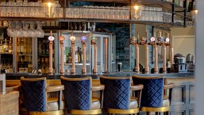A bar with four stools, a beer tap, and a glass rack. - The Bold Hotel, BW Signature Collection (Southport)