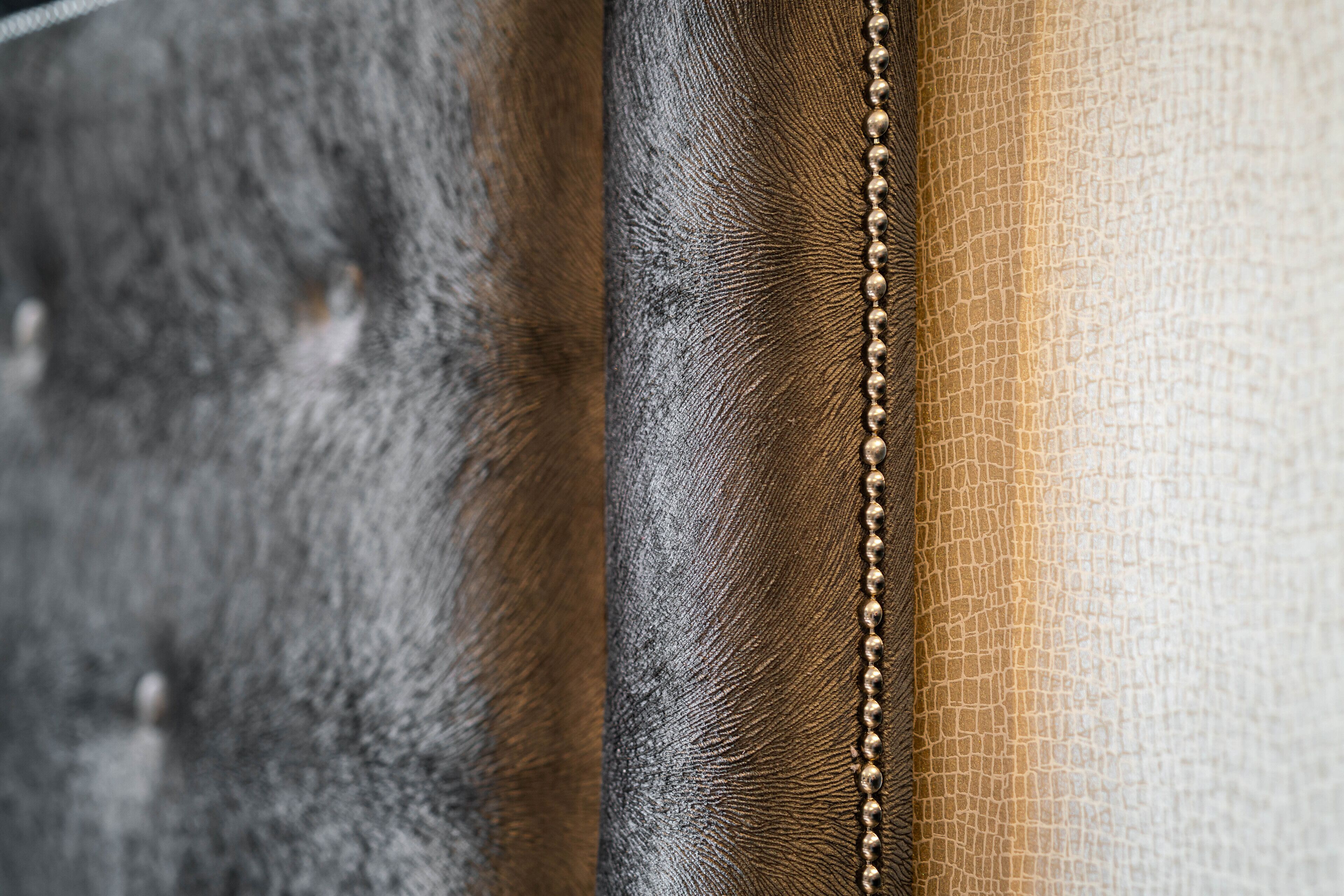 A close-up of a textured fabric with a beaded edge, likely part of a piece of furniture or decor.