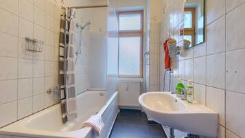 Un baño con bañera, lavamanos y ducha.