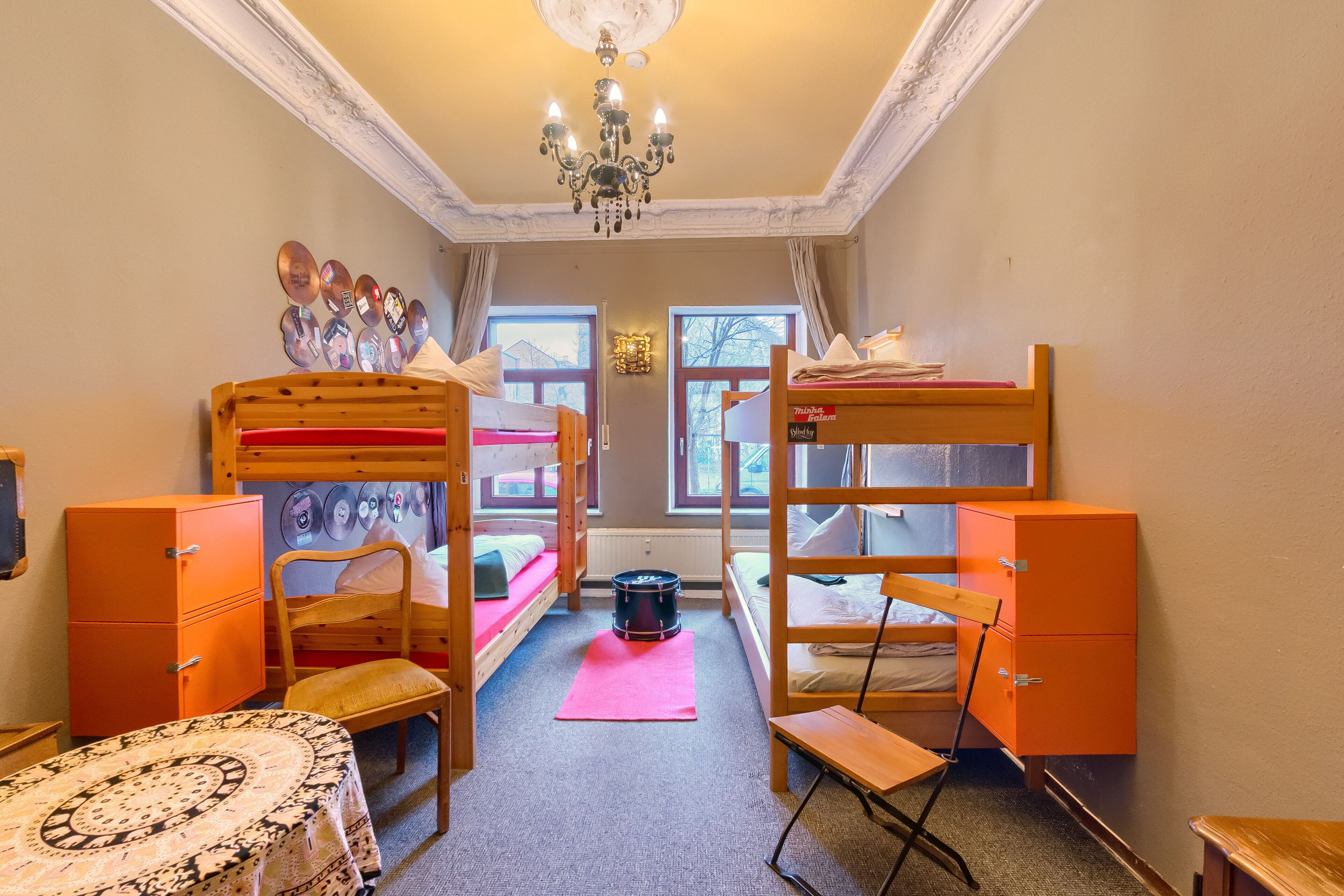 Ein Schlafsaalzimmer mit Etagenbetten, einem Schreibtisch, einem Stuhl und einem Tisch.