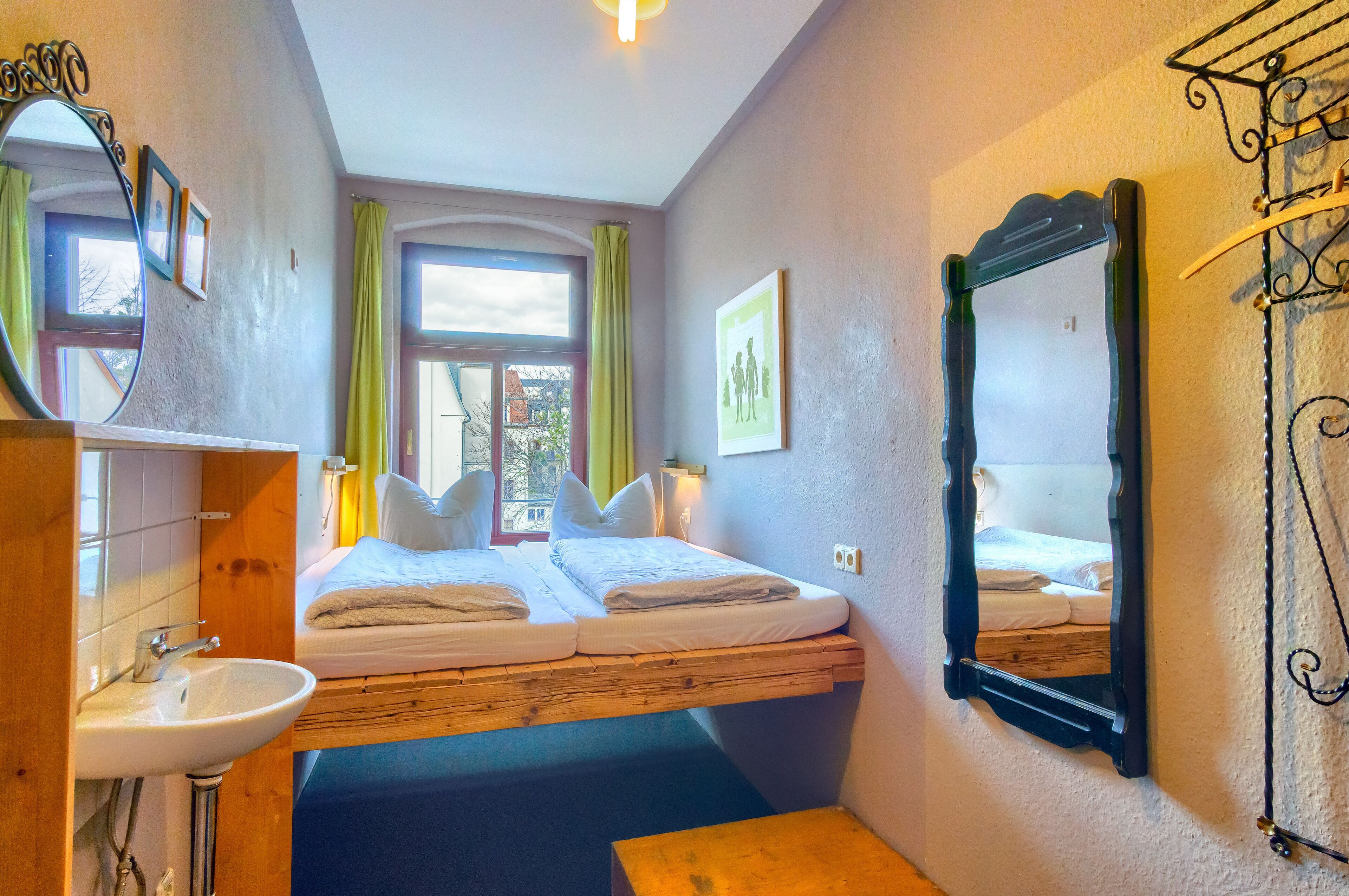Una habitación con una cama, un lavabo y un espejo.