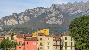 A town with colorful buildings and a mountain backdrop. - Don Abbondio (Lecco)