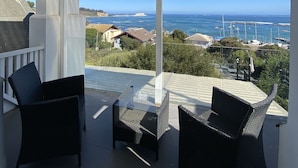 Un espacio de estar al aire libre cubierto con vista al mar y a los barcos.