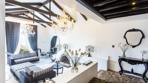 Una sala de estar moderna con un sofá, una mesa de centro, una araña y una consola con un florero.