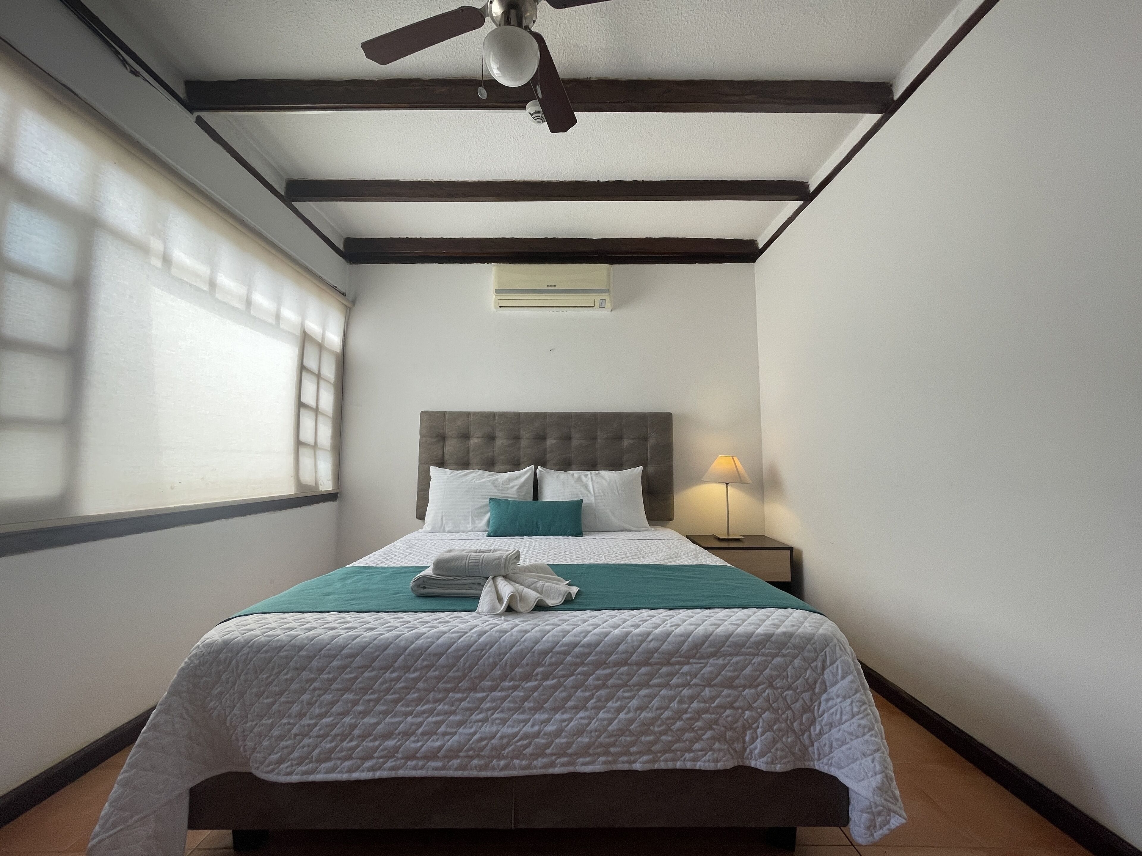 Cubrecamas, tabla de planchar con plancha y ropa de cama 