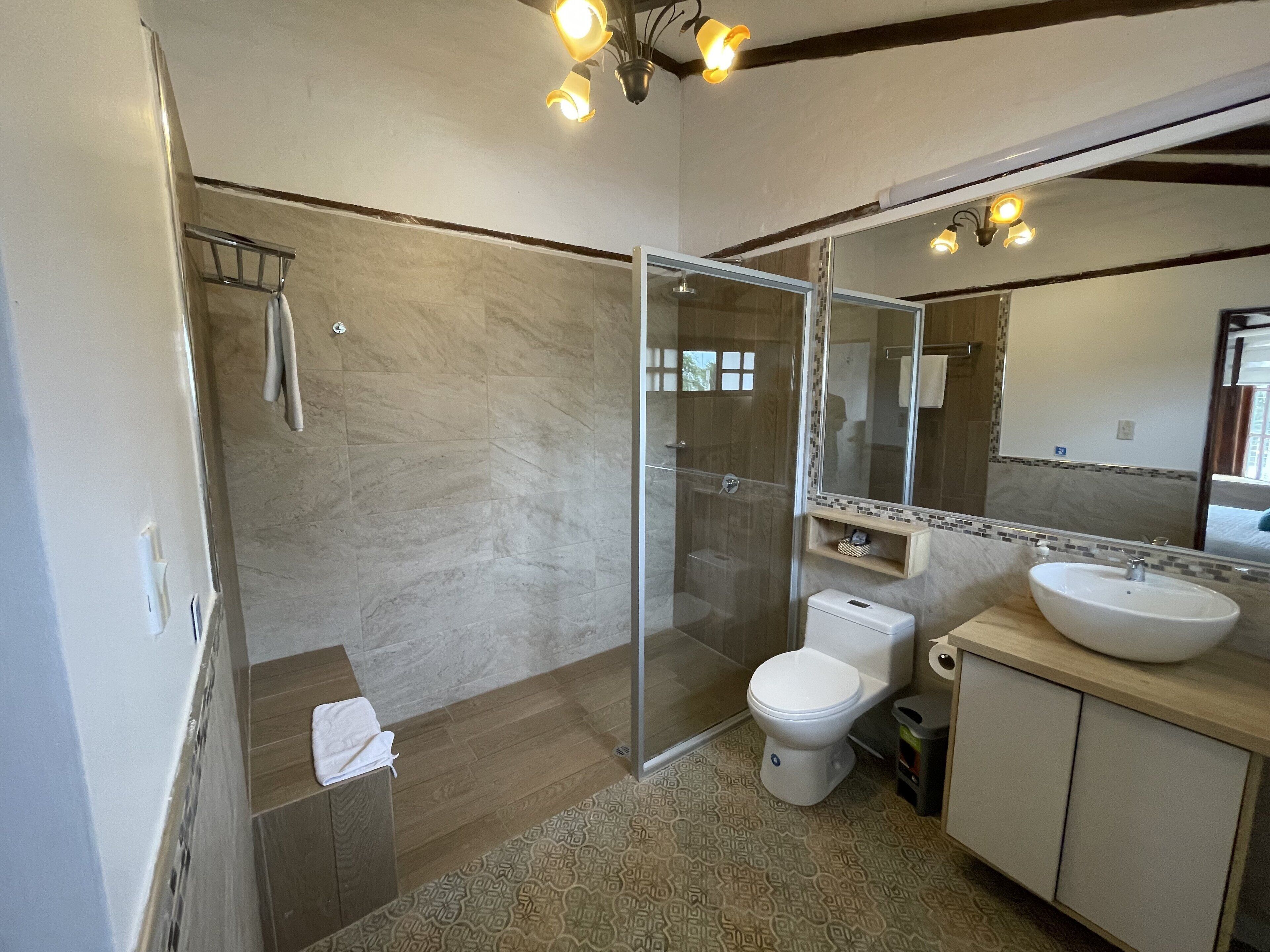 Un baño moderno con cabina de ducha acristalada, inodoro y lavamanos.