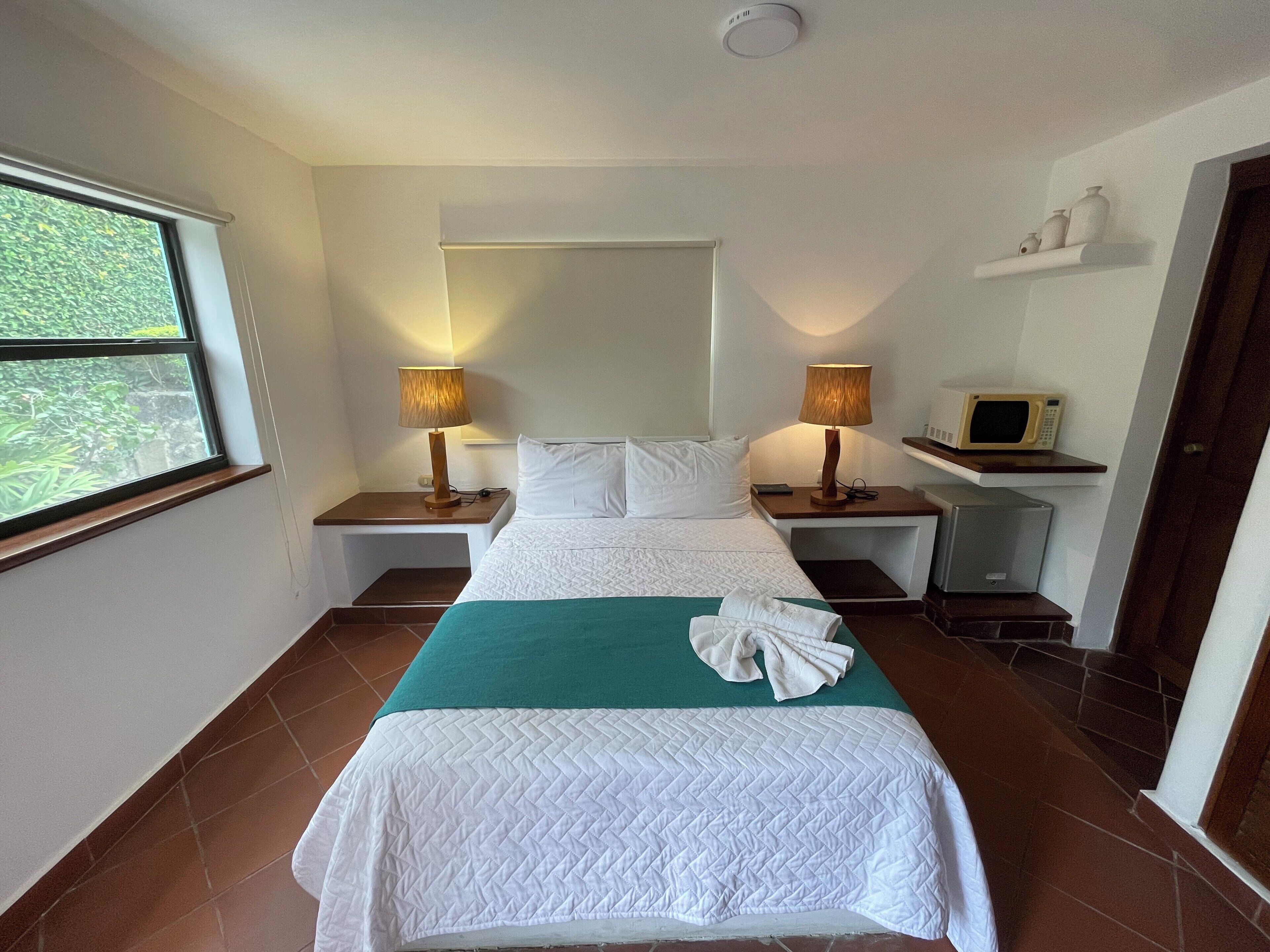 Cubrecamas, tabla de planchar con plancha y ropa de cama 