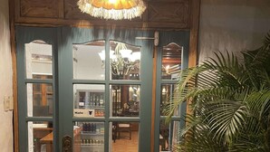 Una puerta verde con varias ventanas y un candelabro colgante.