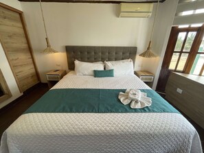 Cubrecamas, tabla de planchar con plancha y ropa de cama 