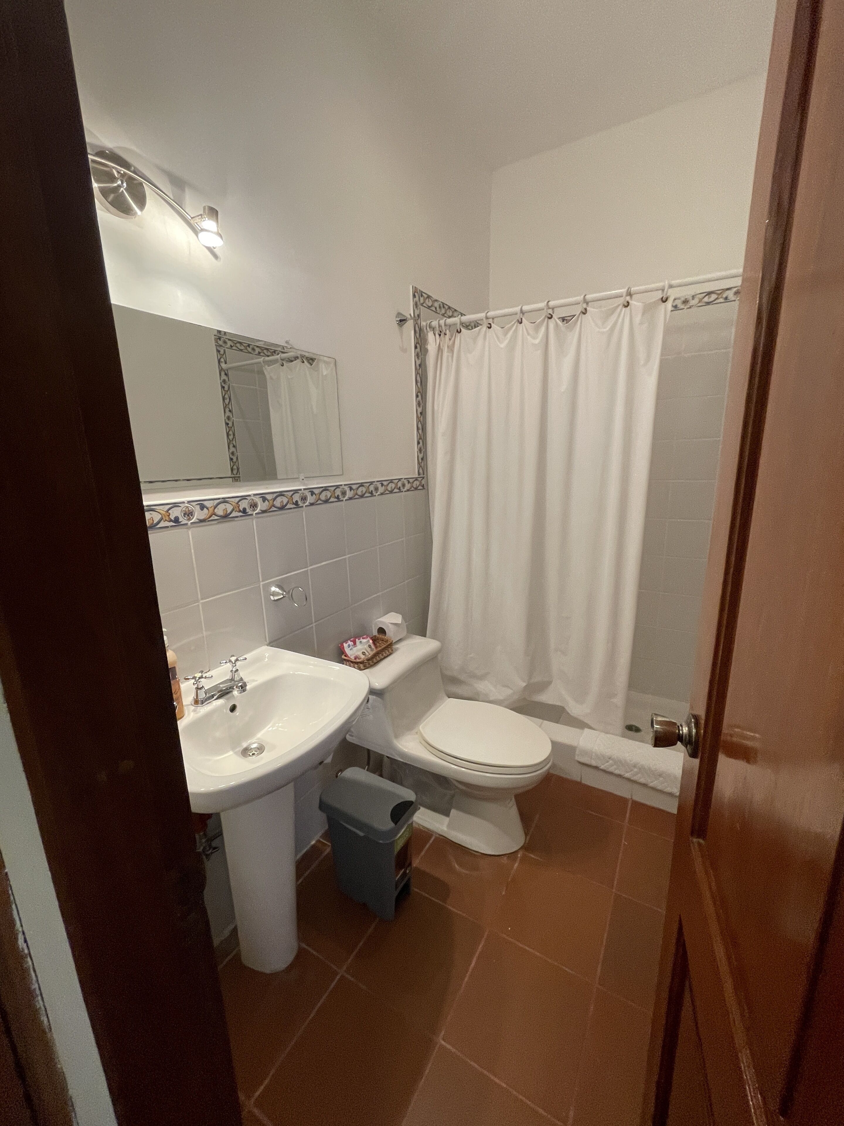 Ein Badezimmer mit Waschbecken, Toilette und Duschvorhang.