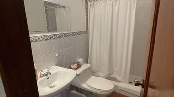 Ein Badezimmer mit Waschbecken, Toilette und Duschvorhang.
