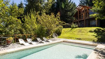 Una piscina al aire libre de temporada, sombrillas