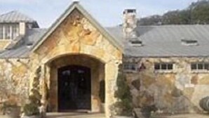 A stone building with a prominent entrance and a large door. - Square Inn (Wimberley)