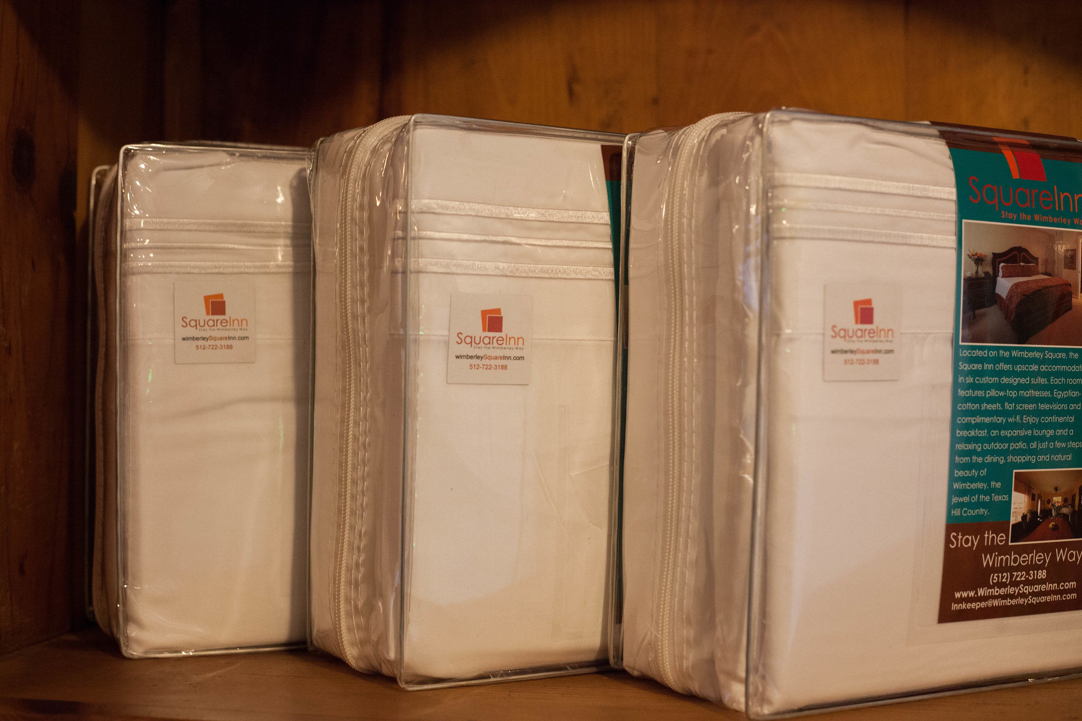 Three mattresses wrapped in plastic, labeled 'SquareInn' with a website and phone number.