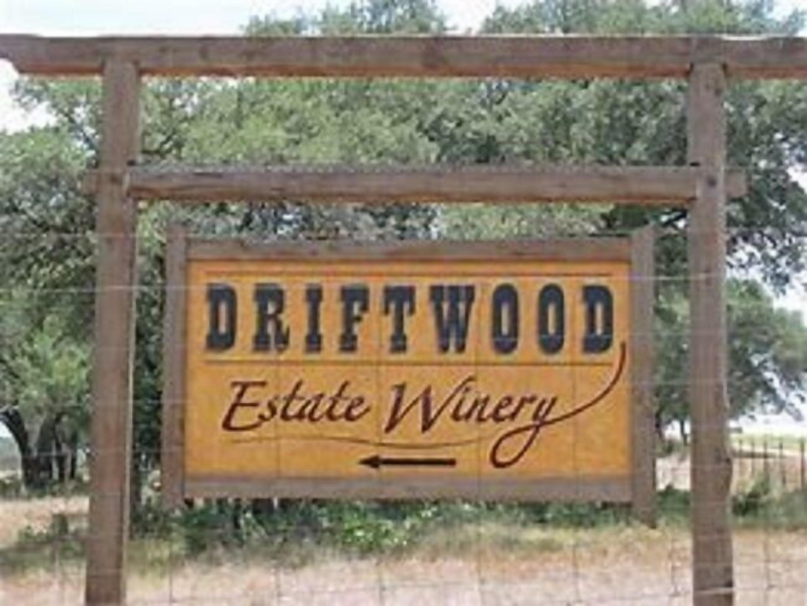 A wooden sign with the text "DRIFTWOOD Estate Winery" and an arrow pointing to the right.