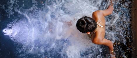 Una persona en una bañera con agua salpicando.