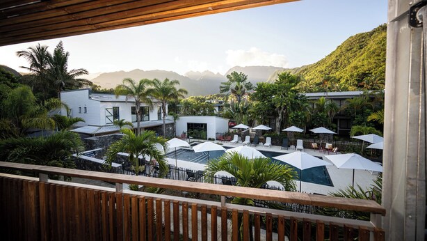Un resort con piscina, sillas de descanso y sombrillas.