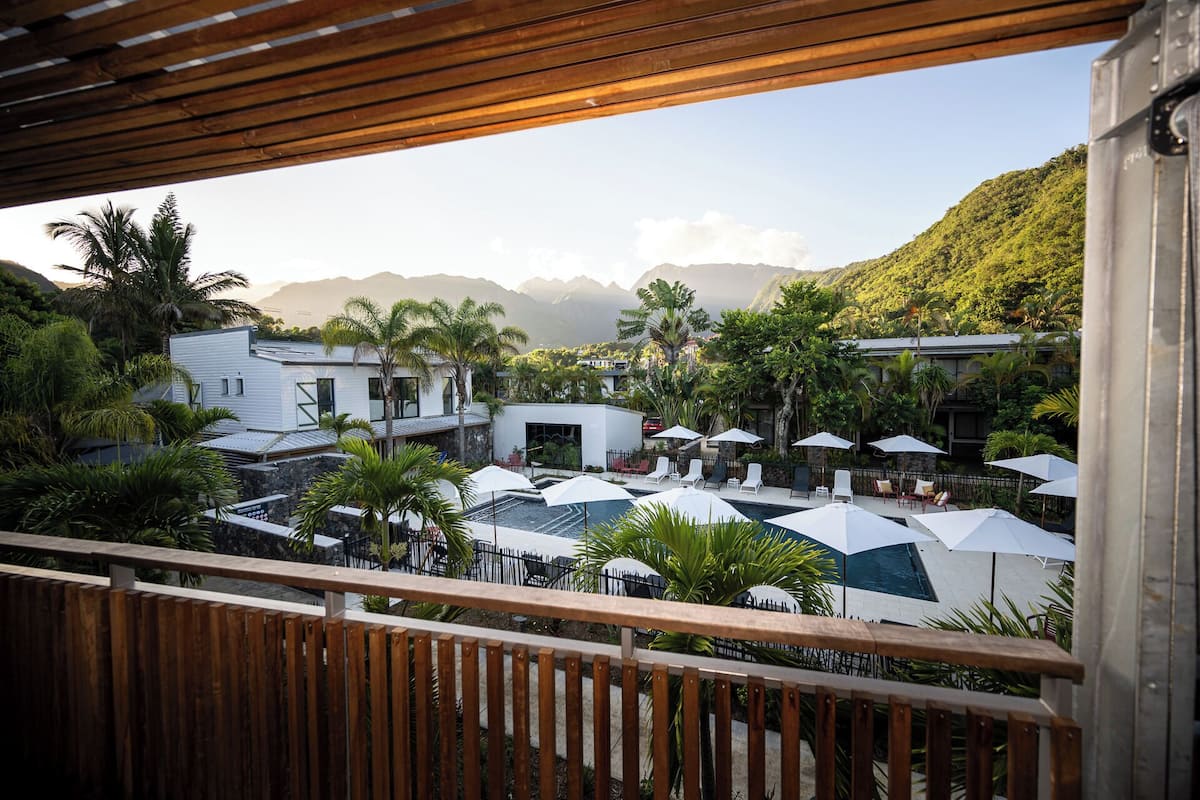 Resort com área de piscina, espreguiçadeiras e guarda-sóis.