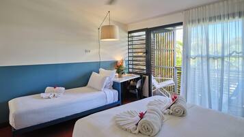 A hotel room with two beds, a desk, a chair, and a large window with a view.