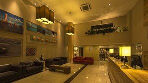 A spacious lobby with a reception desk, two sofas, a coffee table, and artwork on the walls.