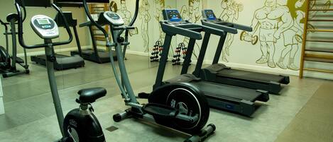 Un gimnasio con cintas de correr, elípticas y bicicletas estáticas.