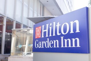A blue sign for Hilton Garden Inn with the hotel logo and name.