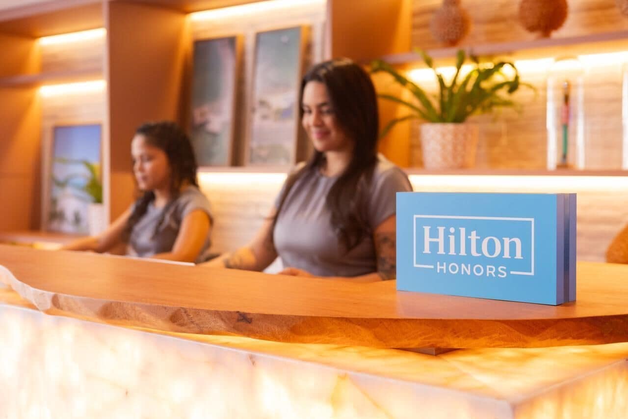 Ein Empfangsschalter mit einem blauen Schild, auf dem 'Hilton Honors' steht.
