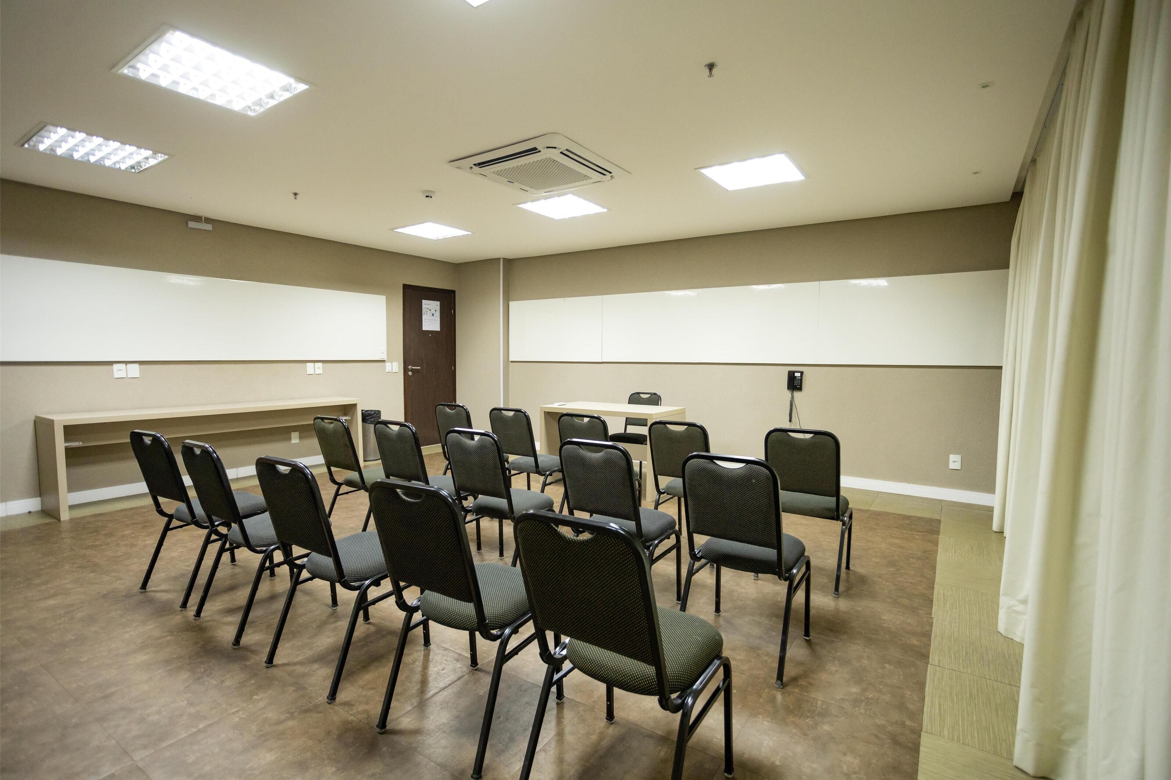 A conference room with a long table and chairs arranged around it.