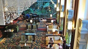 A hotel lobby with multiple seating areas, a central staircase, and a view of the outdoor area. - éL Hotel Bandung (Bandung)