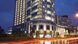A high-rise hotel with multiple floors, large windows, and a distinctive curved top section. - éL Hotel Bandung (Bandung)
