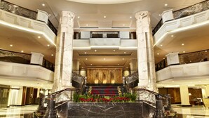 A spacious lobby with marble floors, a central staircase, and multiple balconies. - éL Hotel Bandung (Bandung)