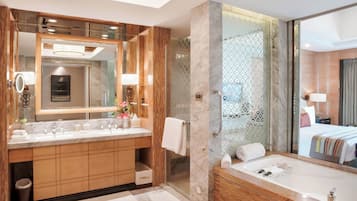 Un baño moderno con un espejo grande, dos lavamanos, una bañera y una ducha.