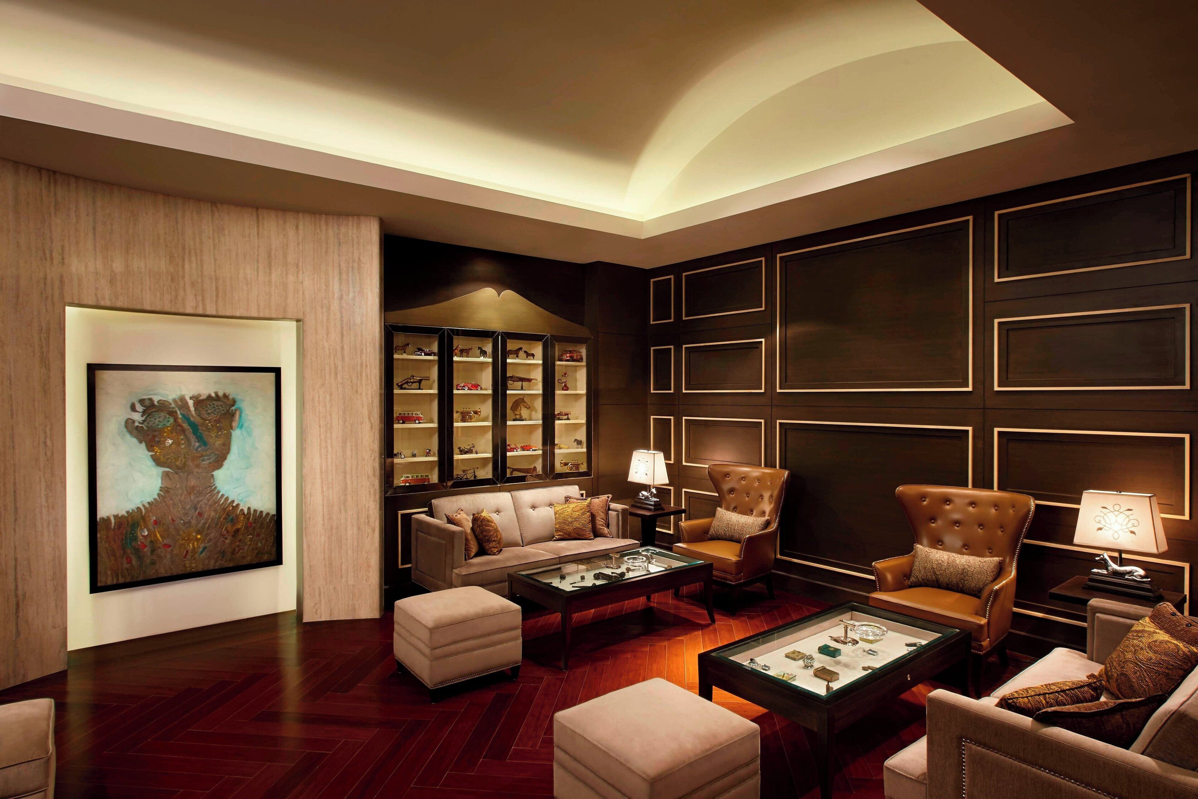 A luxurious living room with a sofa, armchairs, a coffee table, and a bookshelf.