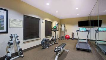 A fitness center with treadmills, a bench, dumbbells, and a stationary bike.