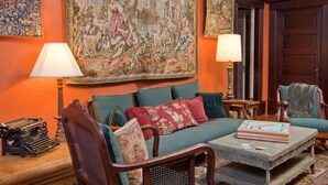 A cozy living room with a large tapestry, a sofa set, and a coffee table. - Kelley & Young Wine Garden Inn (Cloverdale)