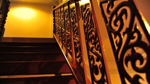 A wooden staircase with ornate metal railings. - Magic House Hostel (Cha-am)