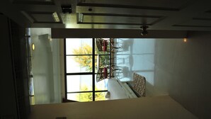 A room with a large window, a radiator, and a ceiling fan. - Magic House Hostel (Cha-am)