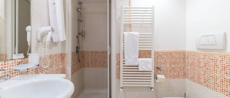 A bathroom with a shower, toilet, and sink.
