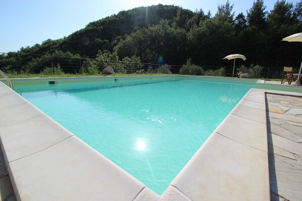 Piscine extérieure, parasols de plage, chaises longues