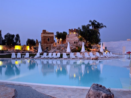 Una piscina al aire libre, sillones reclinables de piscina