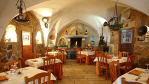 A restaurant with stone walls, wooden tables, and a fireplace. - Tenute Al Bano (Cellino San Marco)