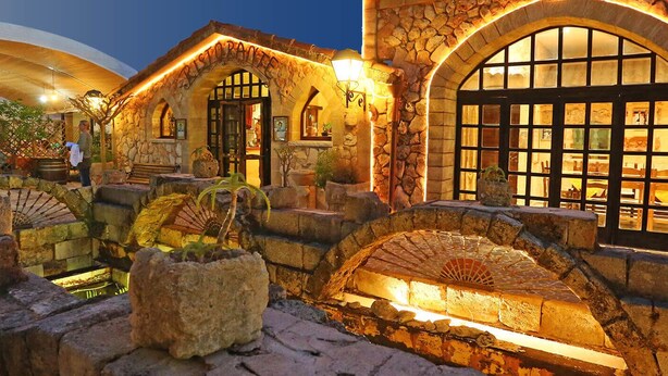 A stone building with arched windows and a covered outdoor seating area. - Tenute Al Bano (Cellino San Marco)