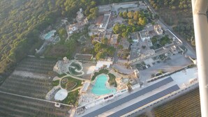 An aerial view of a resort with multiple buildings, swimming pools, and solar panels. - Tenute Al Bano (Cellino San Marco)