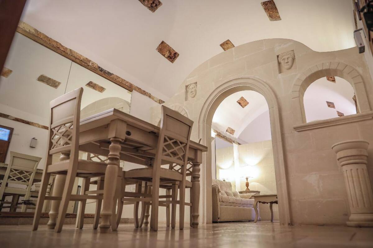 A room with a high ceiling, arched doorways, and a wooden chair.