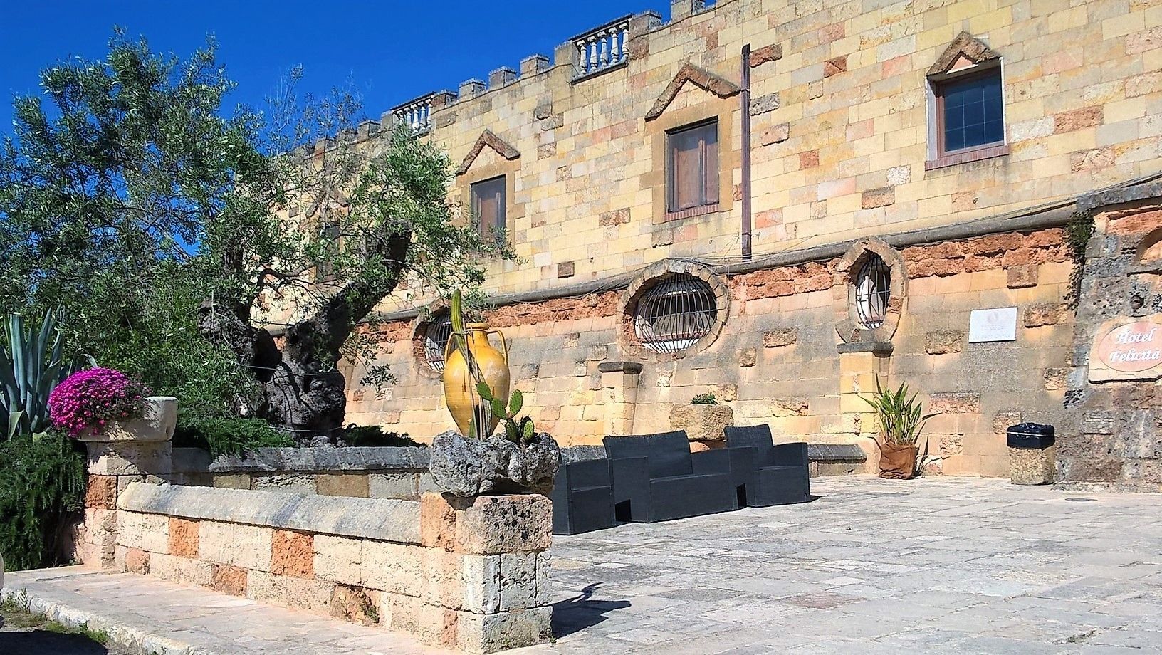 A stone building with a sign for Hotel Felicita.