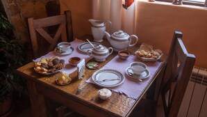 Una mesa de madera dispuesta con servicio de té, platos y una variedad de pasteles.