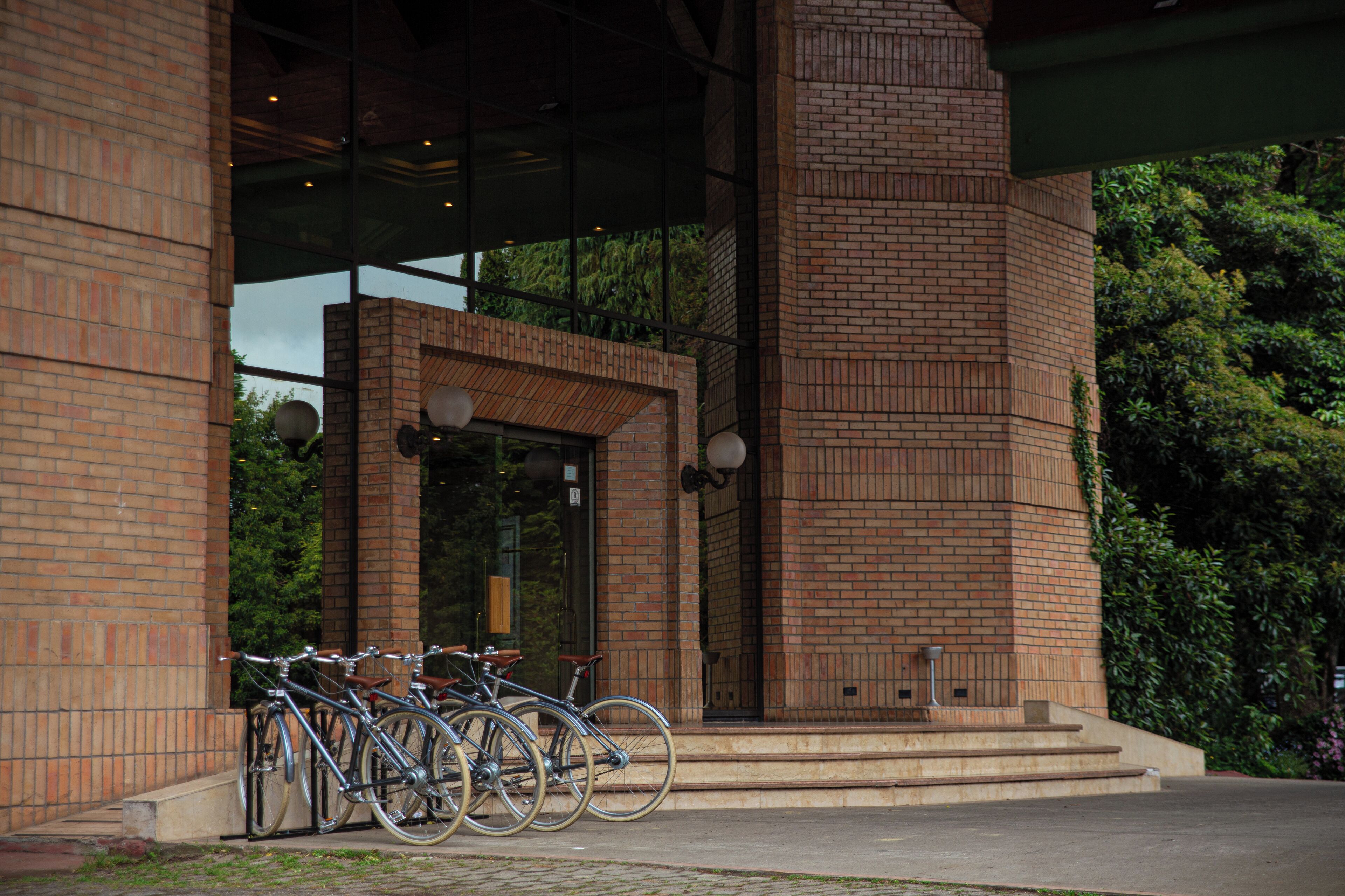 A building entrance with a brick facade, a glass door, and steps leading up to it.