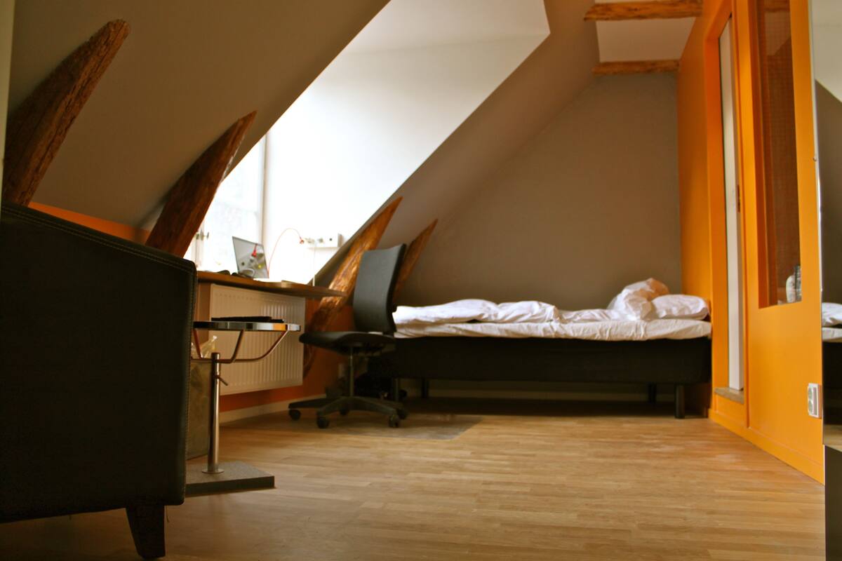 Une chambre à coucher avec un lit, un bureau et une chaise.