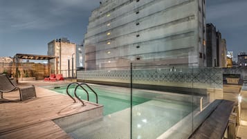Una piscina al aire libre, sombrillas