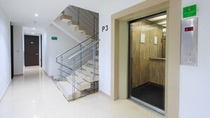 Un intérieur moderne avec un escalier, un ascenseur et un panneau indiquant l’emplacement, qui est le P3.